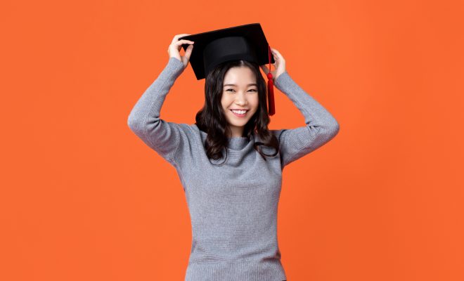 Lady wearing a graduation cap and smiling.